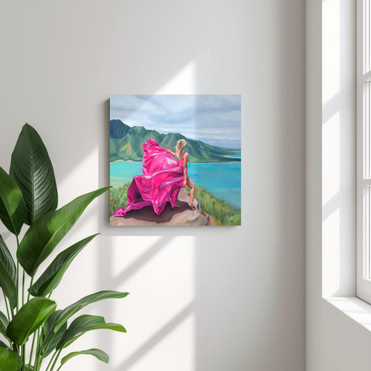 Painting on canvas of a woman in a pink dress standing on a mountain in Hawaii with a scenic background, placed on a white wall with a tropical plant